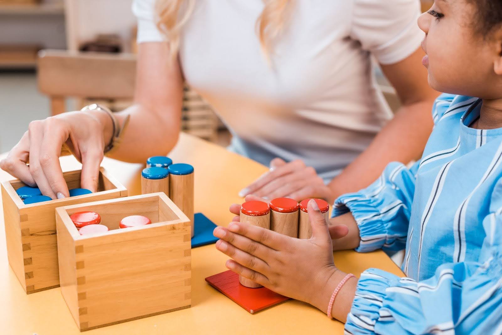 A child and therapist engage in a play therapy session using an educational game at a desk.