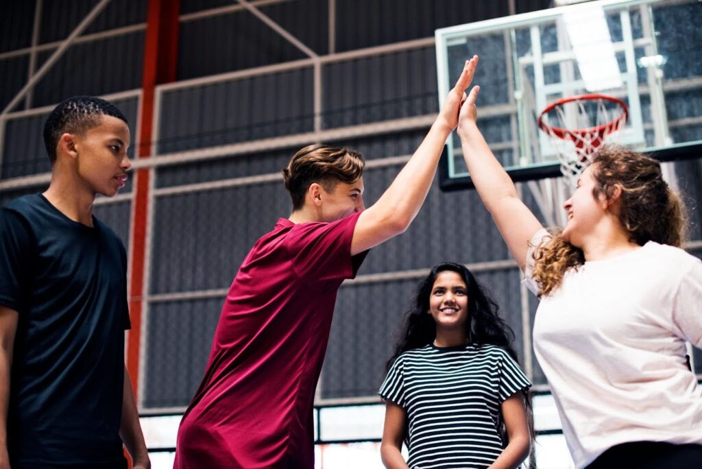 Group of teens celebrating teamwork after a game.
