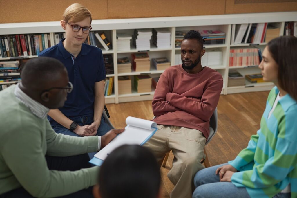 A group therapy session consisting of three adults and their therapist.