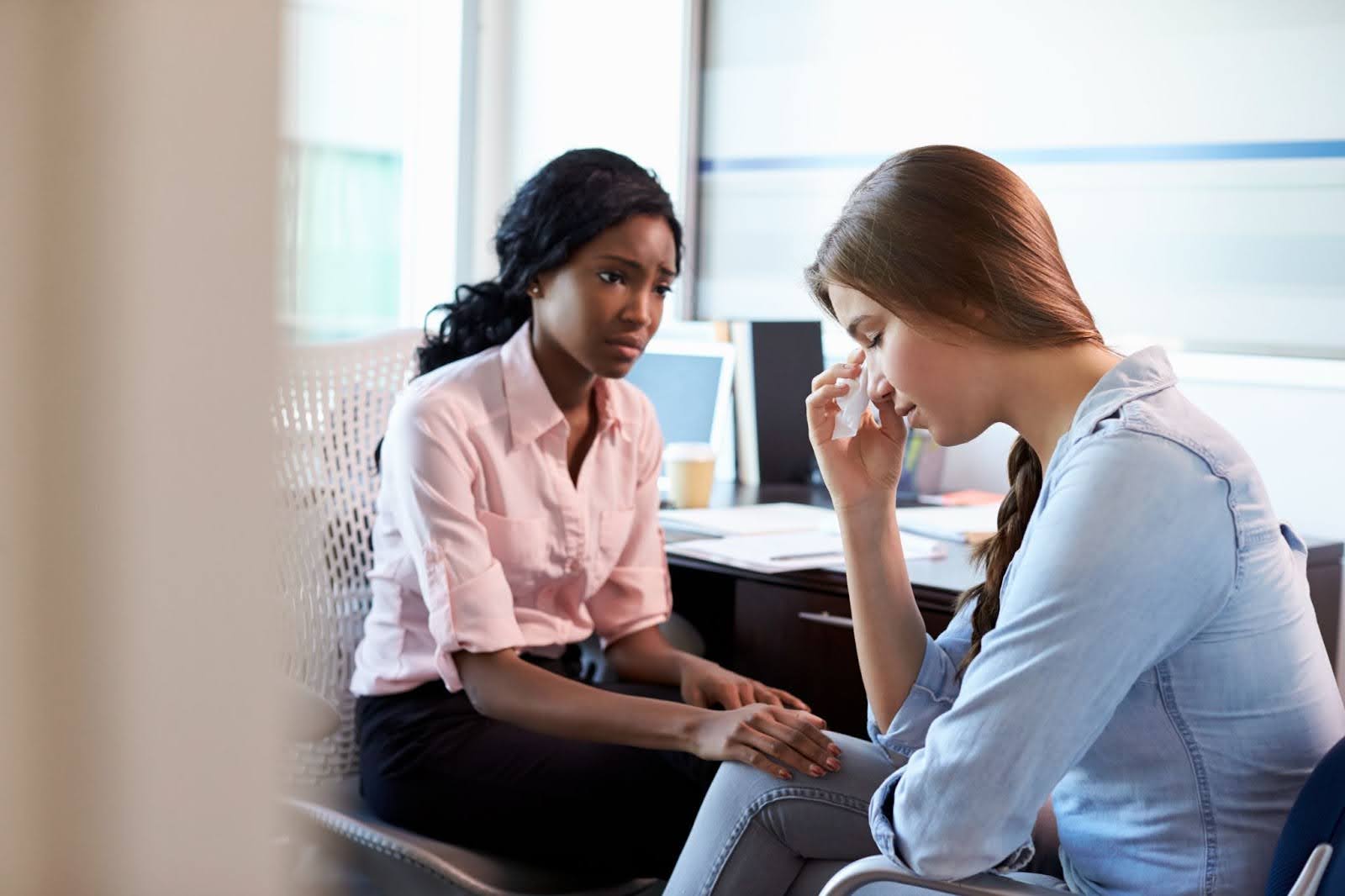 A patient puts her hand to her face during depression counseling.
