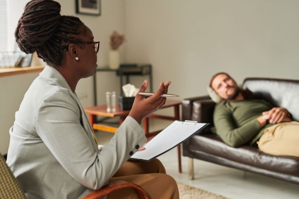 A psychologist speaks to her patient during a counseling session.