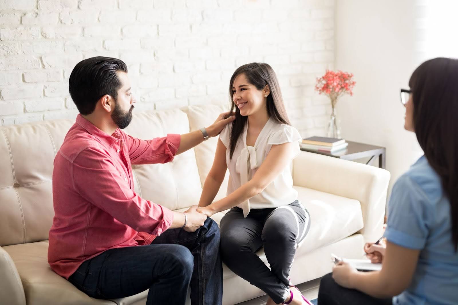 A happy couple looks at each other at a couples counseling session.
